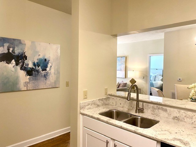 A kitchen with a marble countertop and a painting on the wall.