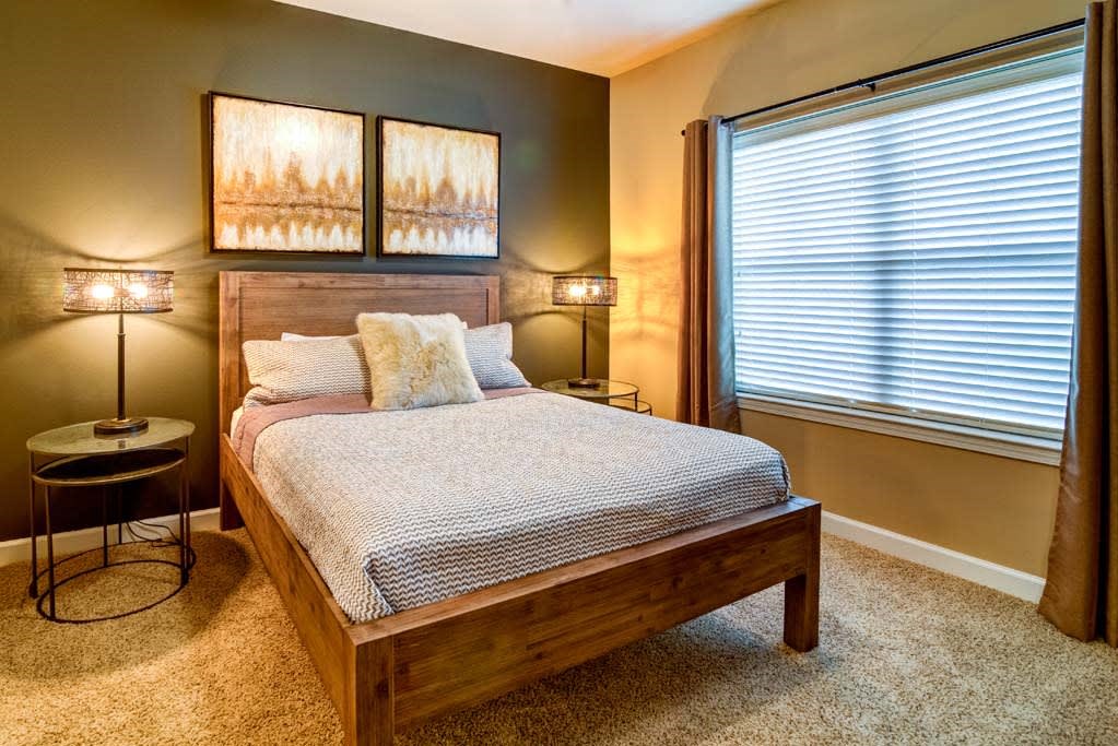 a bedroom with a bed and a window at The Retreat Apartment Homes in Williston, North Dakota