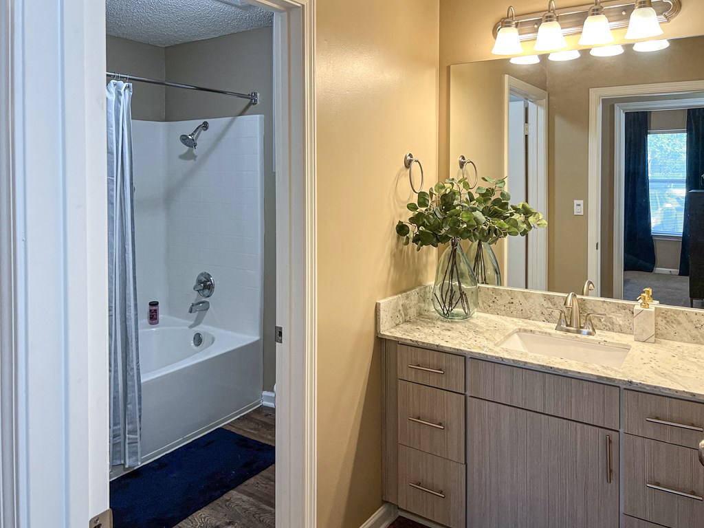 a bathroom with a shower and a sink and a mirror at Reserve at Bossier City in Bossier City, LA 