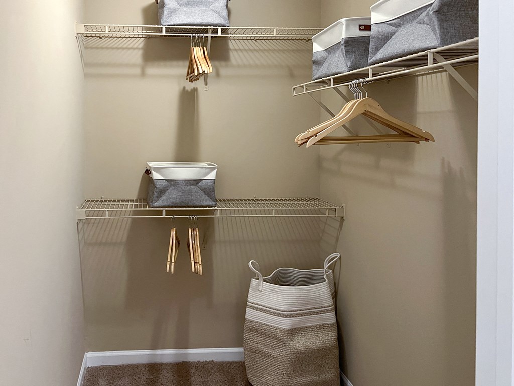 a walk in closet with shelves and baskets and a basket on the floor at Reserve of Bossier City Apartment Homes in LA 71111