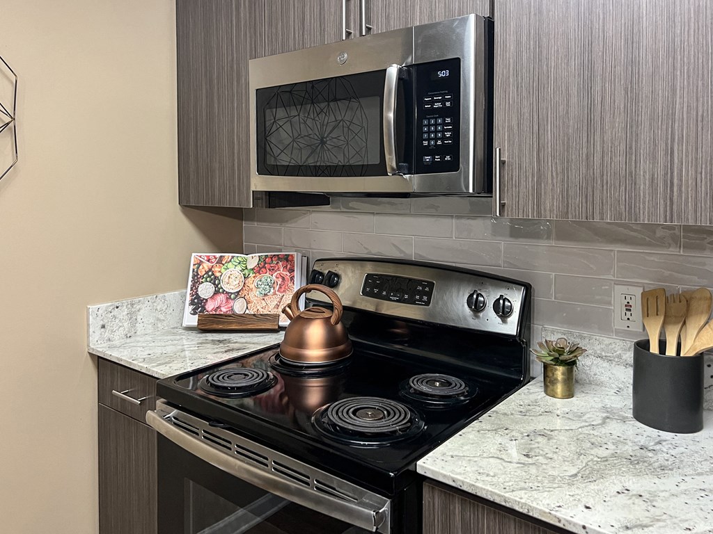a kitchen with a stove and a microwave at Reserve of Bossier City Apartment Homes in Bossier City, LA 71111
