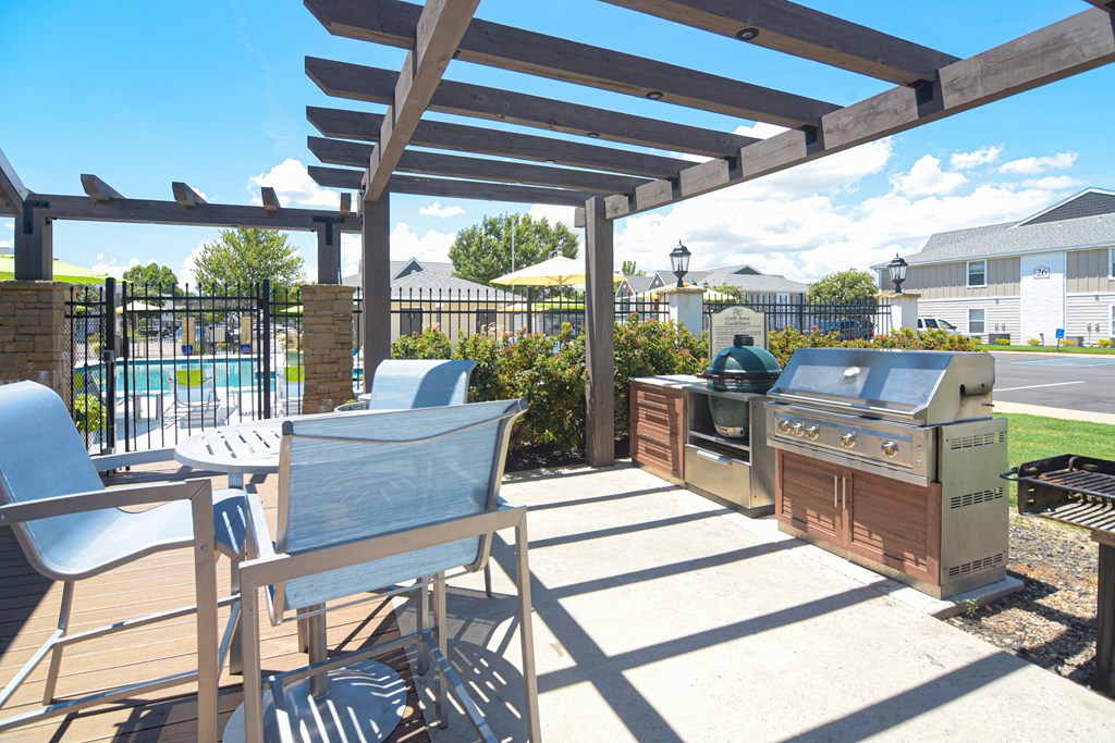 a patio with a barbecue grill and a table with chairs at Reserve of Bossier City Apartment Homes in Bossier City, Louisiana