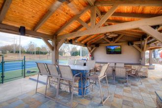 a patio with a table and chairs and a television on the wall