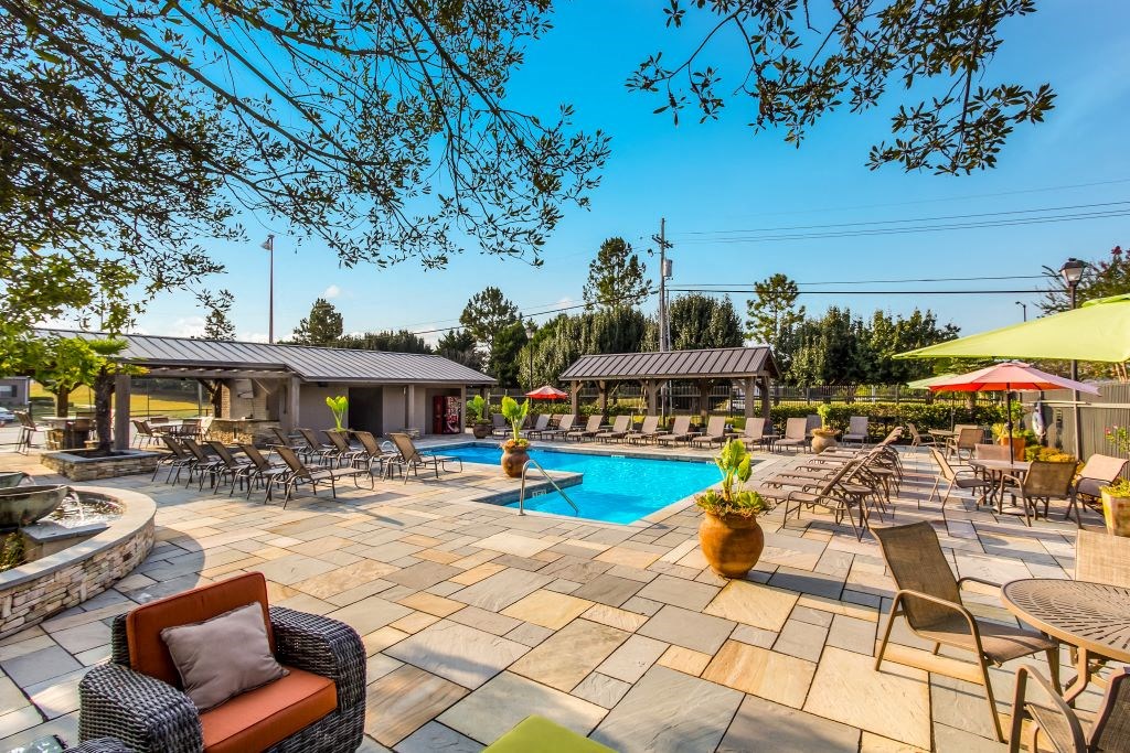 a resort style pool with lounge chairs and umbrellas  at Highpointe Apartment Homes, Brandon, MS, 39042