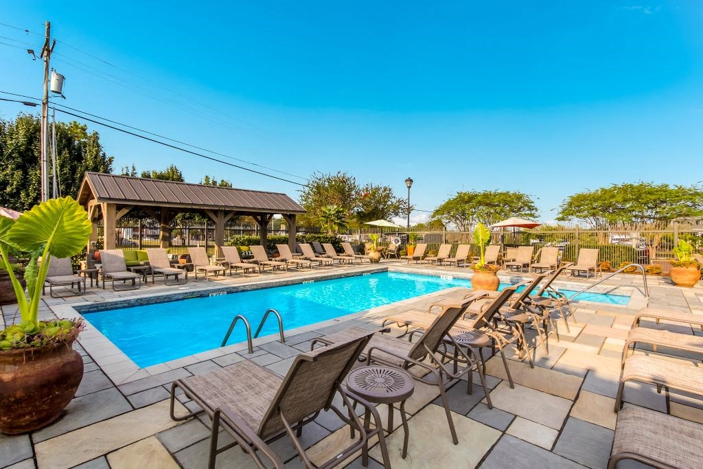 a swimming pool with lounge chairs and umbrellas  at Highpointe Apartment Homes, Brandon, MS, 39042