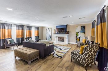 A clubhouse room with a fireplace and a grey couch at Quail Ridge Apartment Homes, Bartlett, 38135
