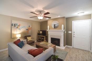 A living room with a grey couch and fireplace in living room at Quail Ridge Apartment Homes, Bartlett, 38135