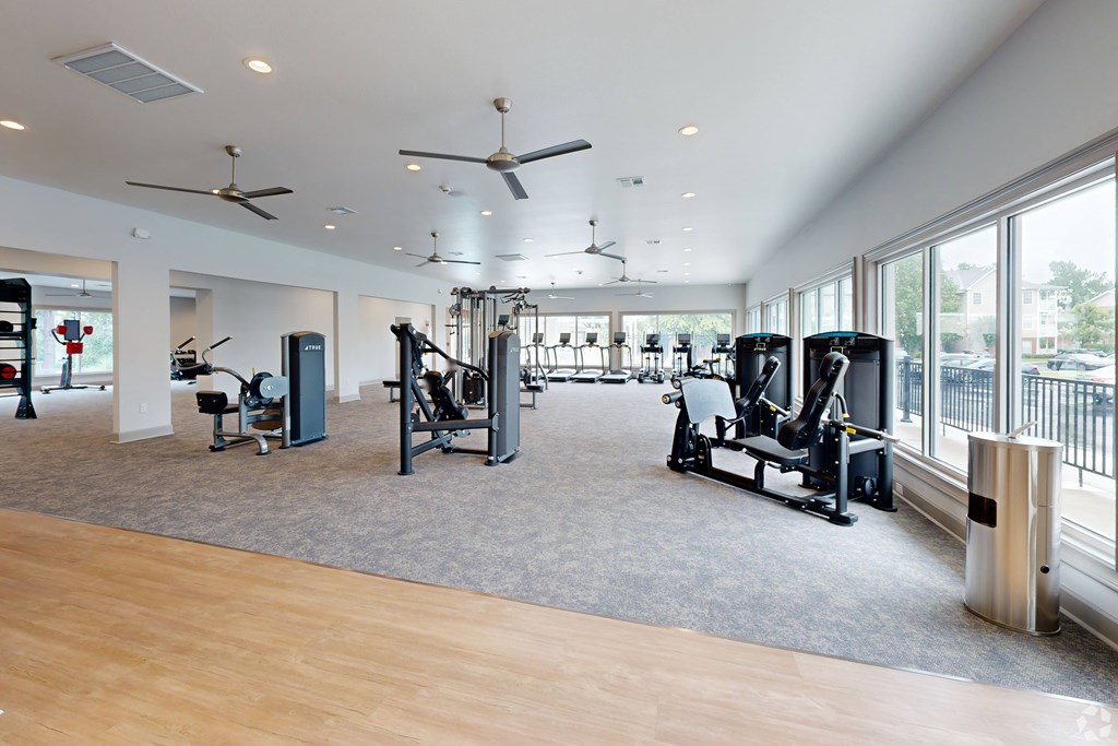 A gym with a variety of equipment including treadmills, weights, and exercise machines. at Reserve at Park Place Apartment Homes, Hattiesburg