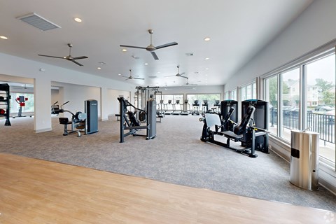 A gym with a variety of equipment including treadmills, weights, and exercise machines. at Reserve at Park Place Apartment Homes, Hattiesburg