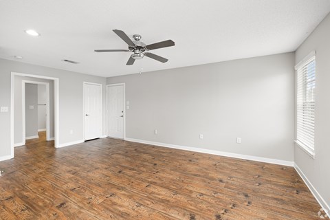 A room with a ceiling fan and wooden flooring. at Reserve at Park Place Apartment Homes, Hattiesburg, MS, 39402