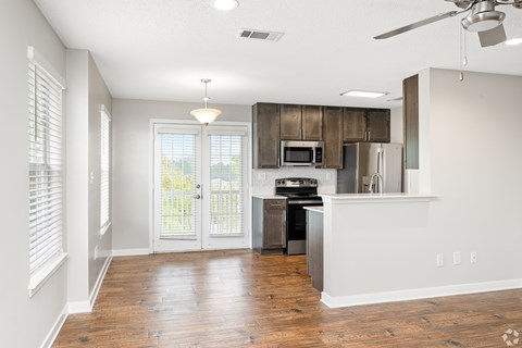 A kitchen with a refrigerator, microwave, and stove top oven.