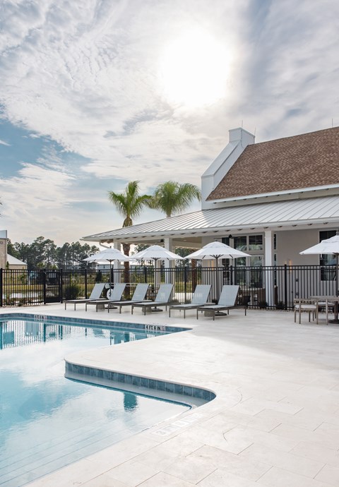 A pool with a white building behind it.