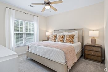 a bedroom with a bed and a ceiling fan at The Met Apartment Homes, Mississippi 39402