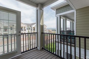 A balcony with a view of the sky and houses at The Retreat Apartment Homes in ND 58801