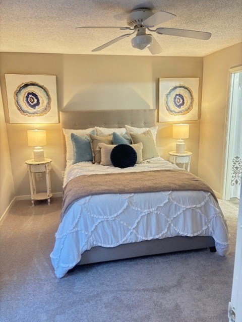 A bedroom with a large bed and two lamps on either side of the bed.