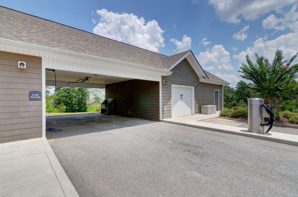 a large garage with a white door and a trash can in front of it