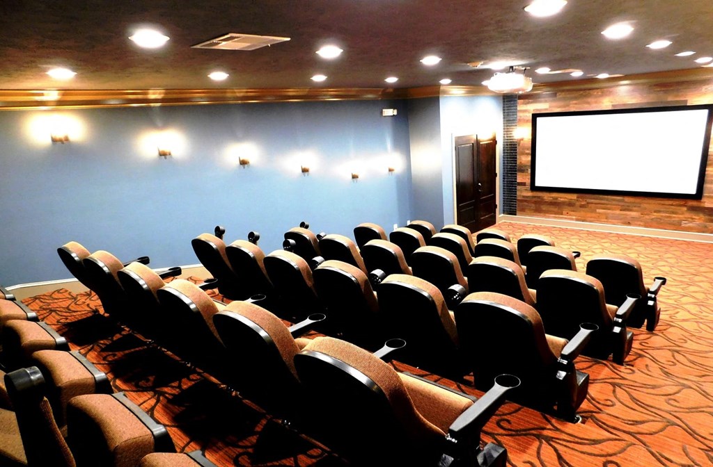 a conference room filled with chairs and a projector screen at Reserve at Gulf Hills Apartment Homes in Ocean Springs, Mississippi