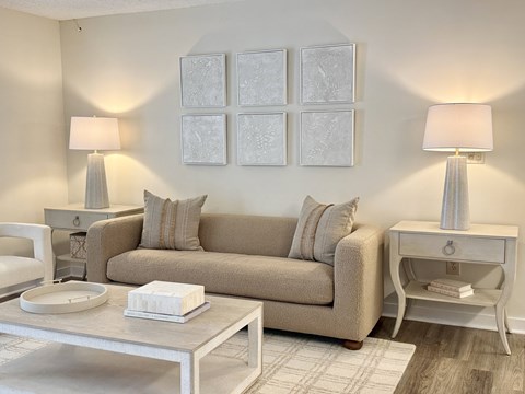 A living room with a beige couch, two lamps, and a coffee table.