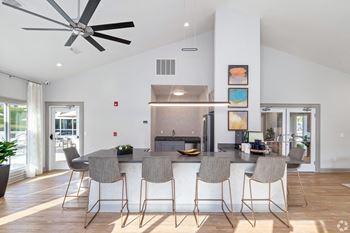 a kitchen with a large island with stools and a ceiling fan at Laurelwood Apartment Homes, Mississippi