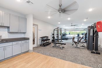 a home gym with exercise equipment and a ceiling fan  at Laurelwood Apartment Homes, Laurel, Mississippi