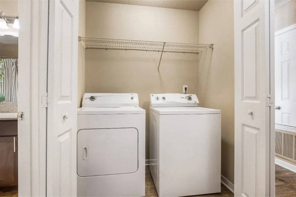 a washer and dryer in a laundry room with a closet at Reserve at Gulf Hills Apartment Homes in MS 39564