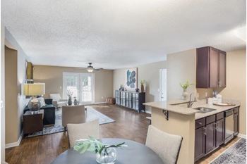 A modern kitchen with a dining table and chairs and hardwood floors at Reserve at Gulf Hills Apartment Homes in Ocean Springs, MS