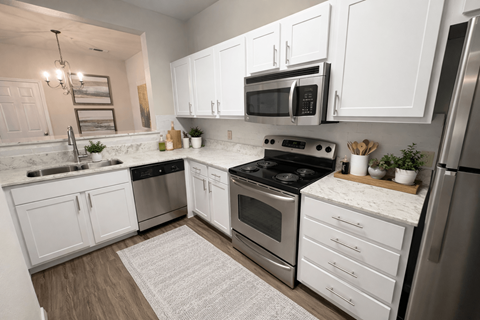 A modern kitchen with white cabinets and stainless steel appliances.