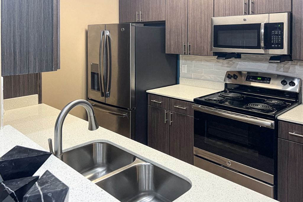 a kitchen with a sink stove refrigerator and microwave at Canebrake Apartment Homes, Louisiana, 71115