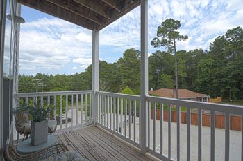 a porch with a view of the trees and a blue sky at The Met Apartment Homes in Hattiesburg, MS