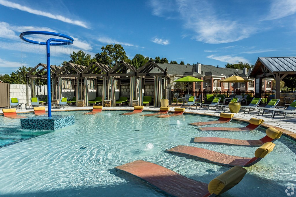 A large outdoor swimming pool with a blue ring in the middle. at Quail Ridge Apartment Homes, Bartlett