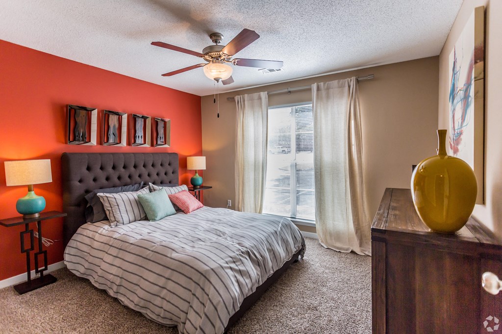 A bedroom with a bed, a dresser, and a ceiling fan. at Quail Ridge Apartment Homes, Bartlett, TN