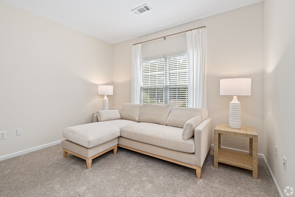 a living room with a couch and a window at The Met Apartment Homes, Hattiesburg, 39402