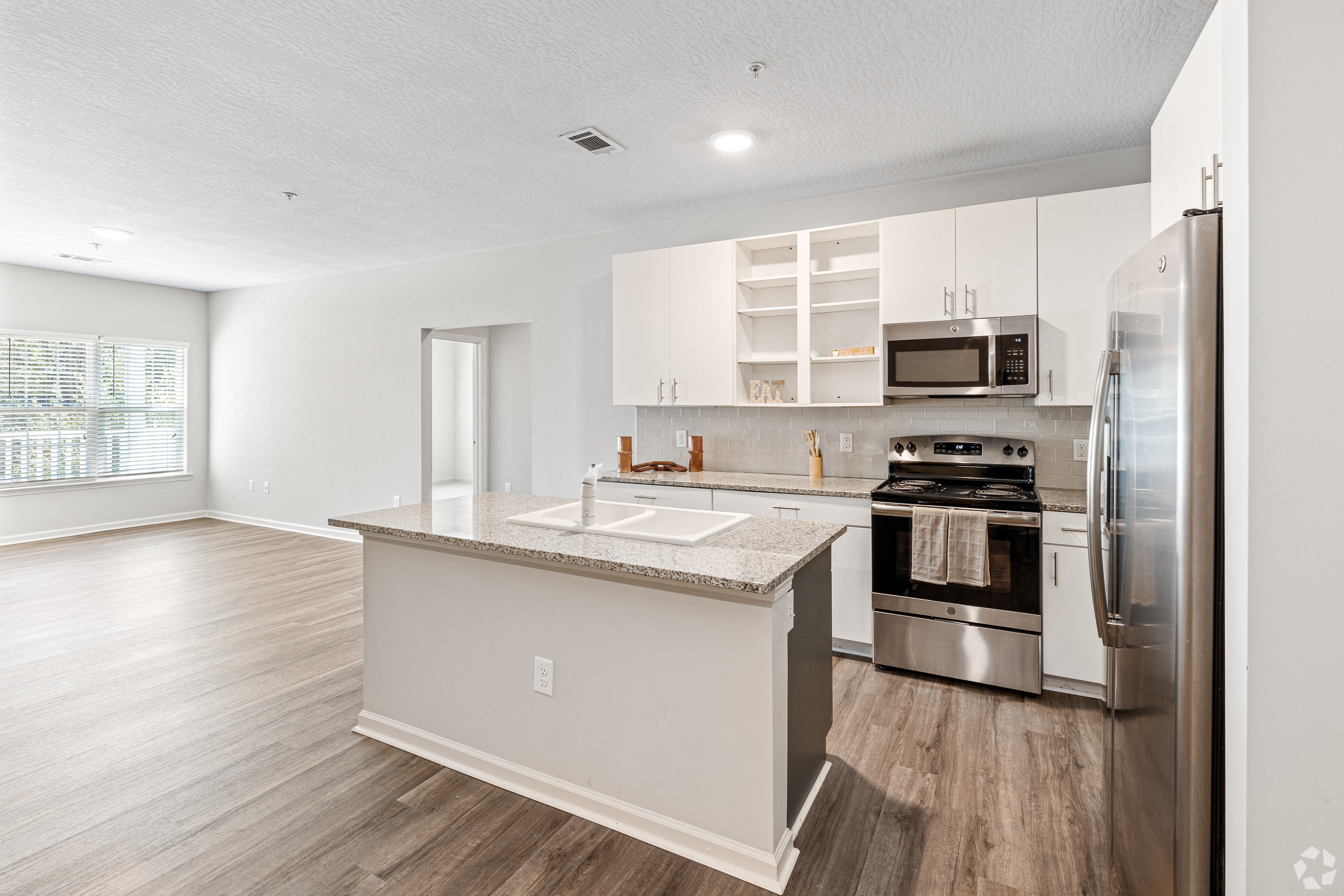 an open kitchen with stainless steel appliances and white cabinets