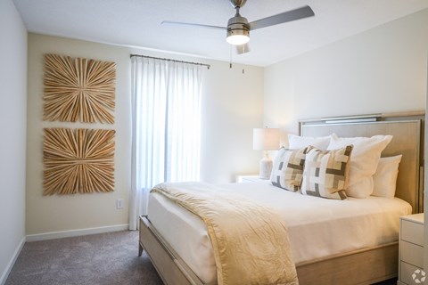 a bedroom with a large bed and a ceiling fan at The Vineyard at Castlewoods Apartment Homes in Brandon, Mississippi 39047