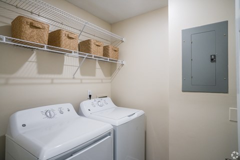 two washers and a dryer in a laundry room with a blue door