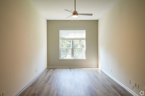 an empty room with a ceiling fan and a window at The Vineyard at Castlewoods Apartment Homes in Brandon, MS