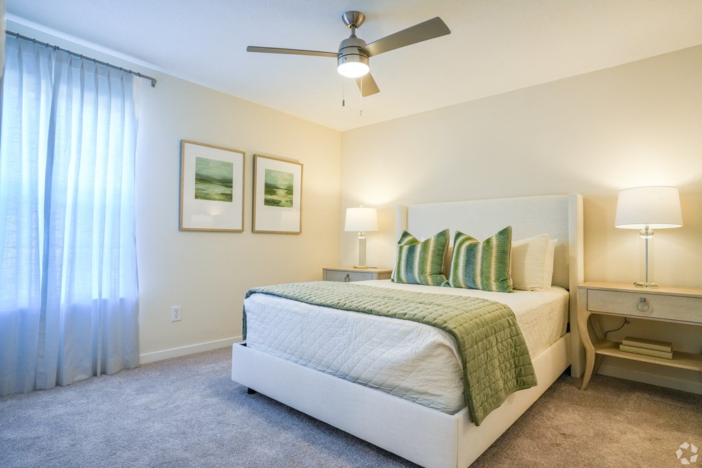 a bedroom with a bed and a ceiling fan at The Vineyard at Castlewoods Apartment Homes in Brandon, MS 39047