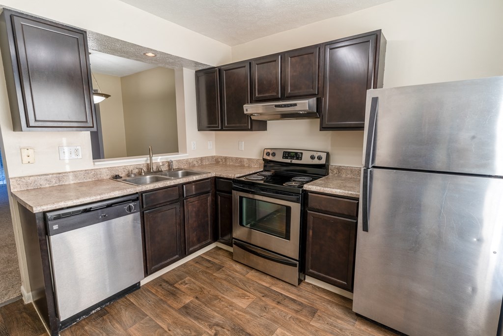 a kitchen with stainless steel appliances and dark wood cabinets
