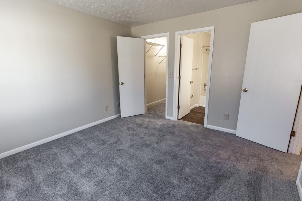 an empty living room with white walls and a carpeted floor