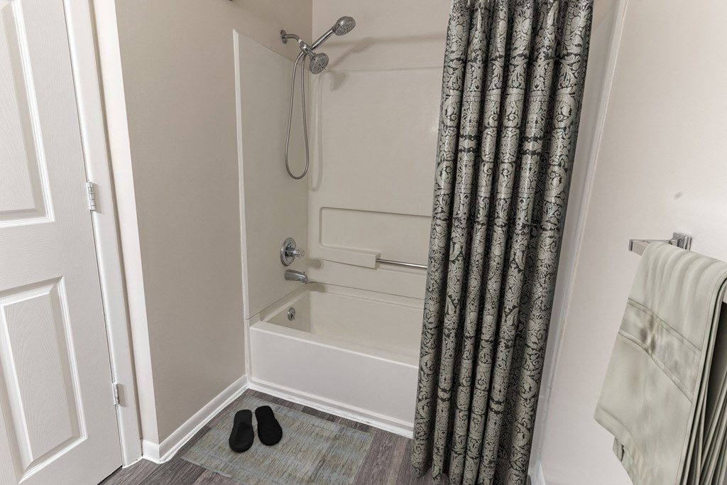a bathroom with a shower and a tub and a shower curtain