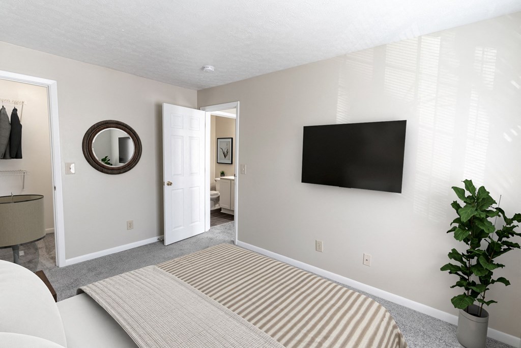 a bedroom with a bed and a television on the wall