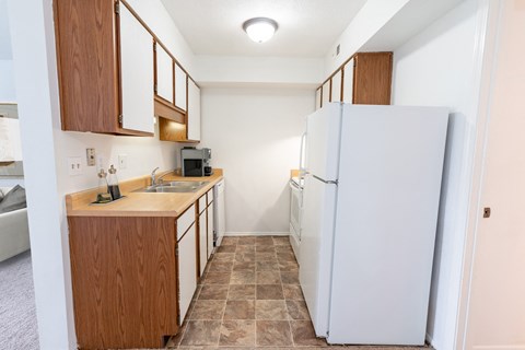 a kitchen with a white refrigerator and a sink