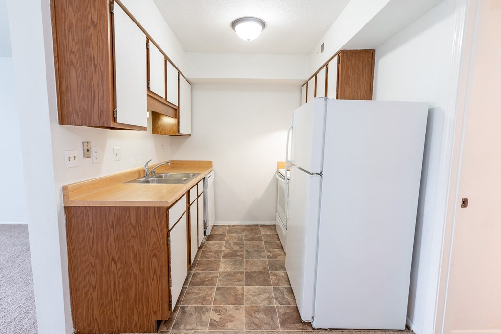 a kitchen with white appliances and wooden cabinets