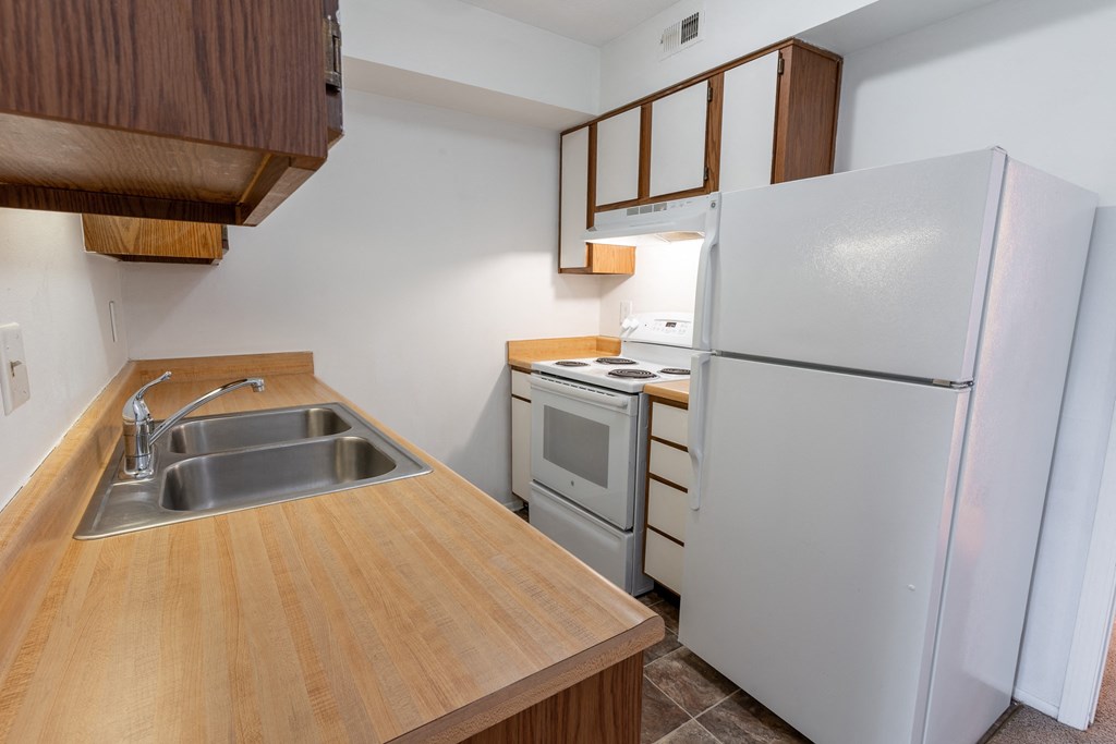 a kitchen with white appliances and wooden cabinets