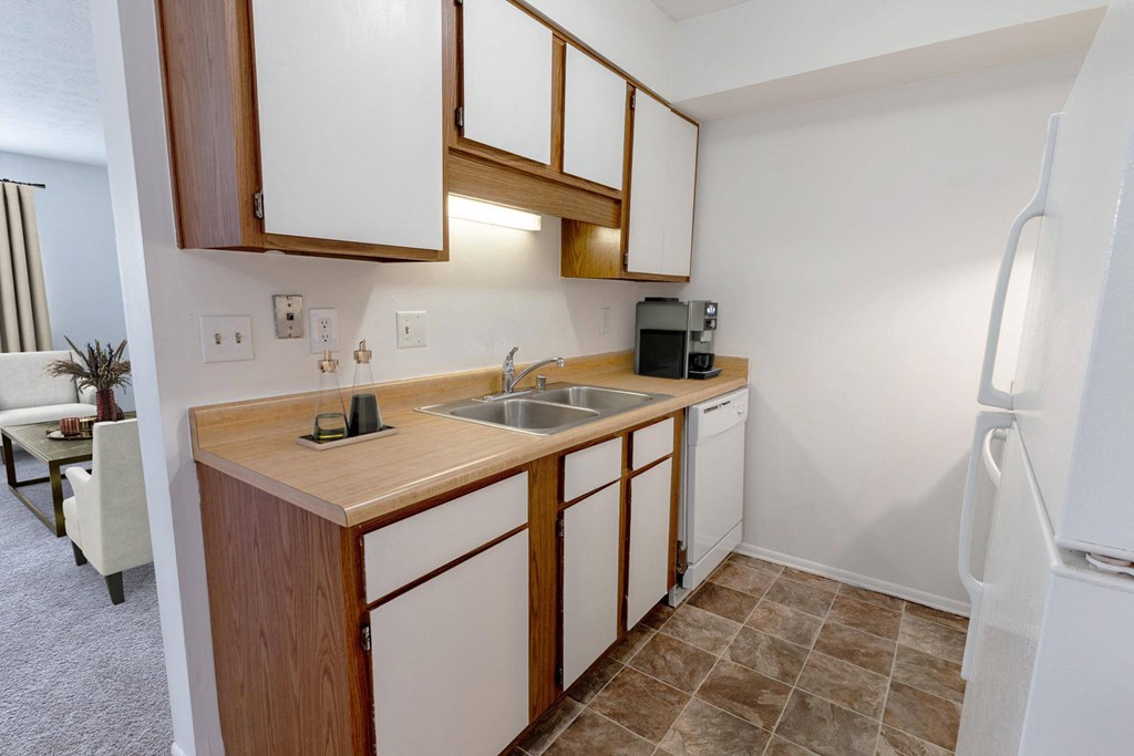 a small kitchen with white cabinets and a stainless steel sink