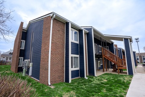 a building with blue siding and green grass