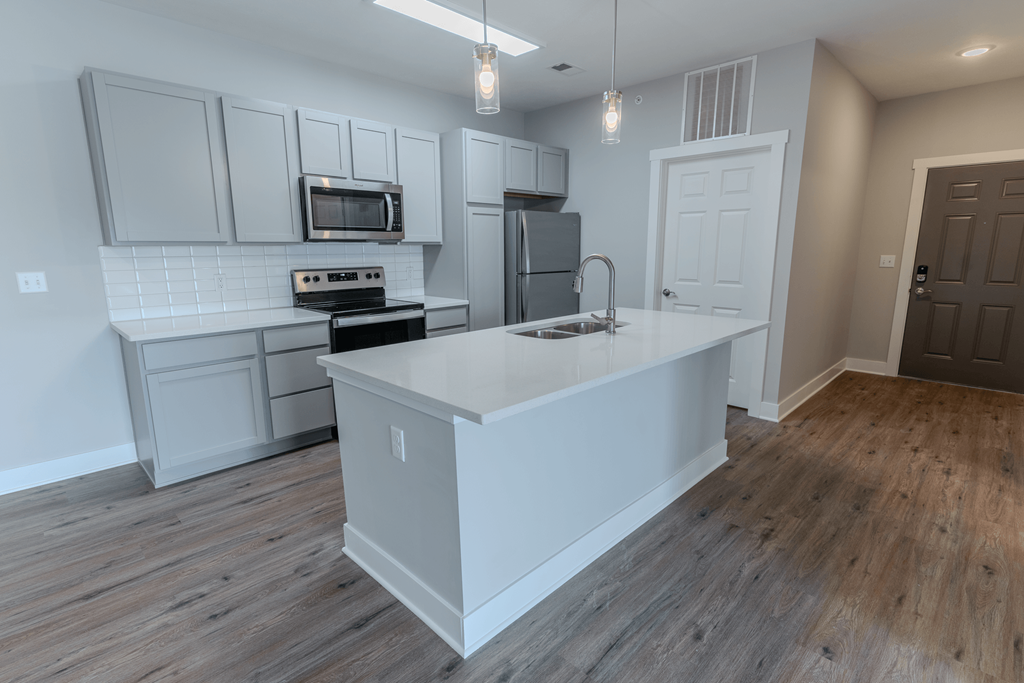 an open kitchen with a large island at The Village at Sandstone Apartments, Greenwood, 46142