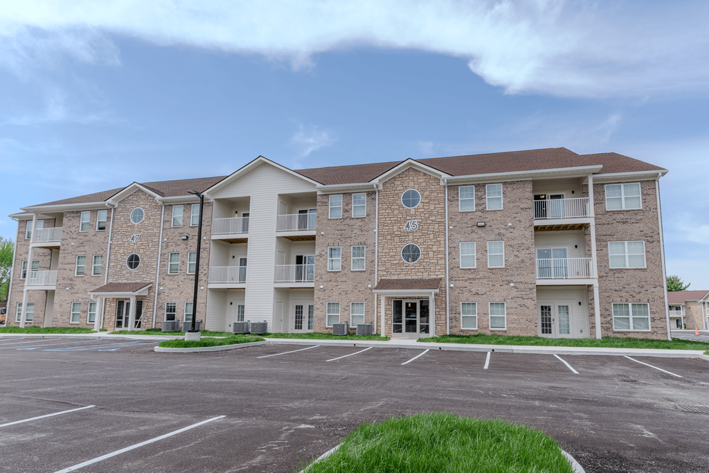 an empty parking lot in front of an apartment building at The Village at Sandstone Apartments, Indiana