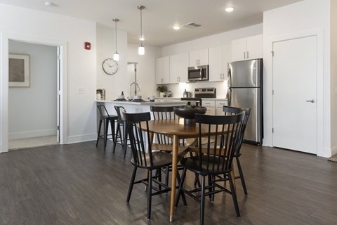 a kitchen and dining area with a table and chairs and a refrigerator