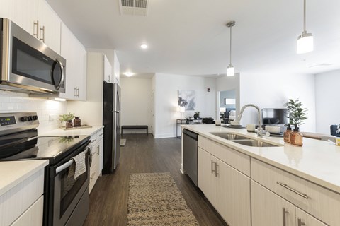 an open kitchen with white counter tops and stainless steel appliances